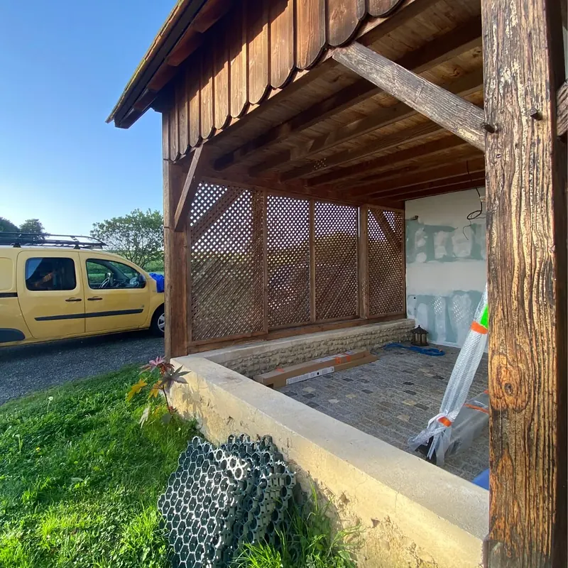 Dépendance vue de l’extérieur pendant les travaux : charpente en bois, treillis encore en place, murs intérieurs en plaques de plâtre