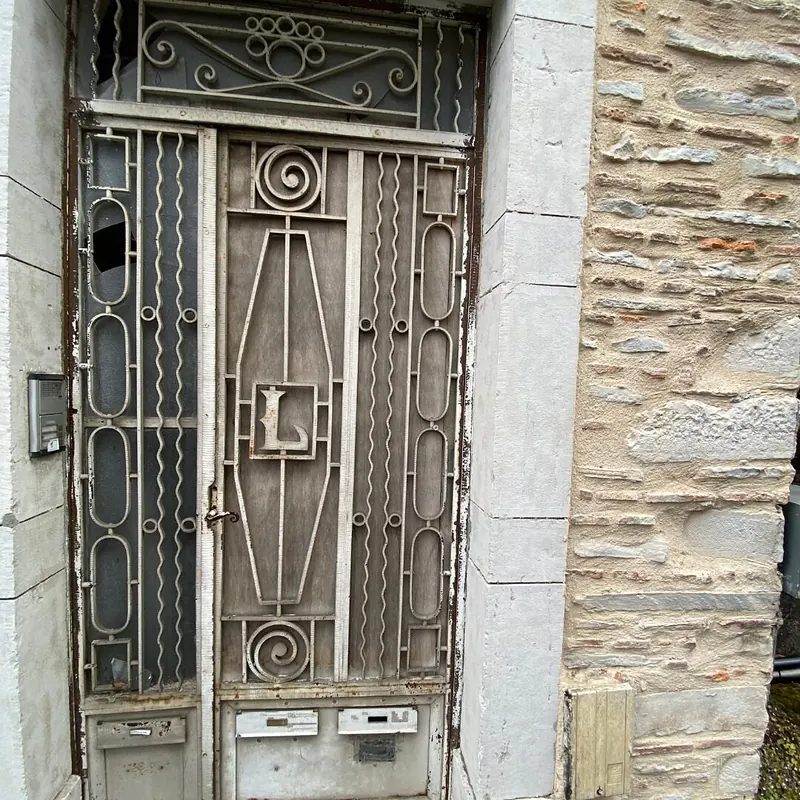 Avant : Ancienne porte d’entrée en fer forgé, vitre cassée, avant son remplacement
