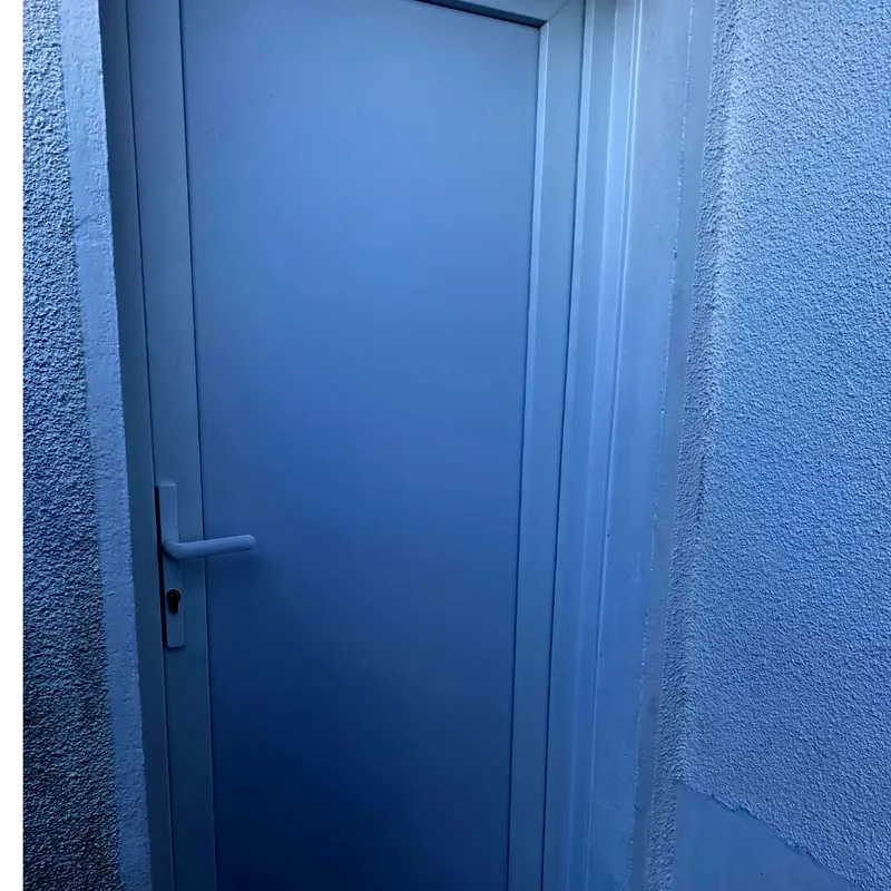 Après : Porte PVC blanche pleine posée dans une ouverture de mur crépi blanc